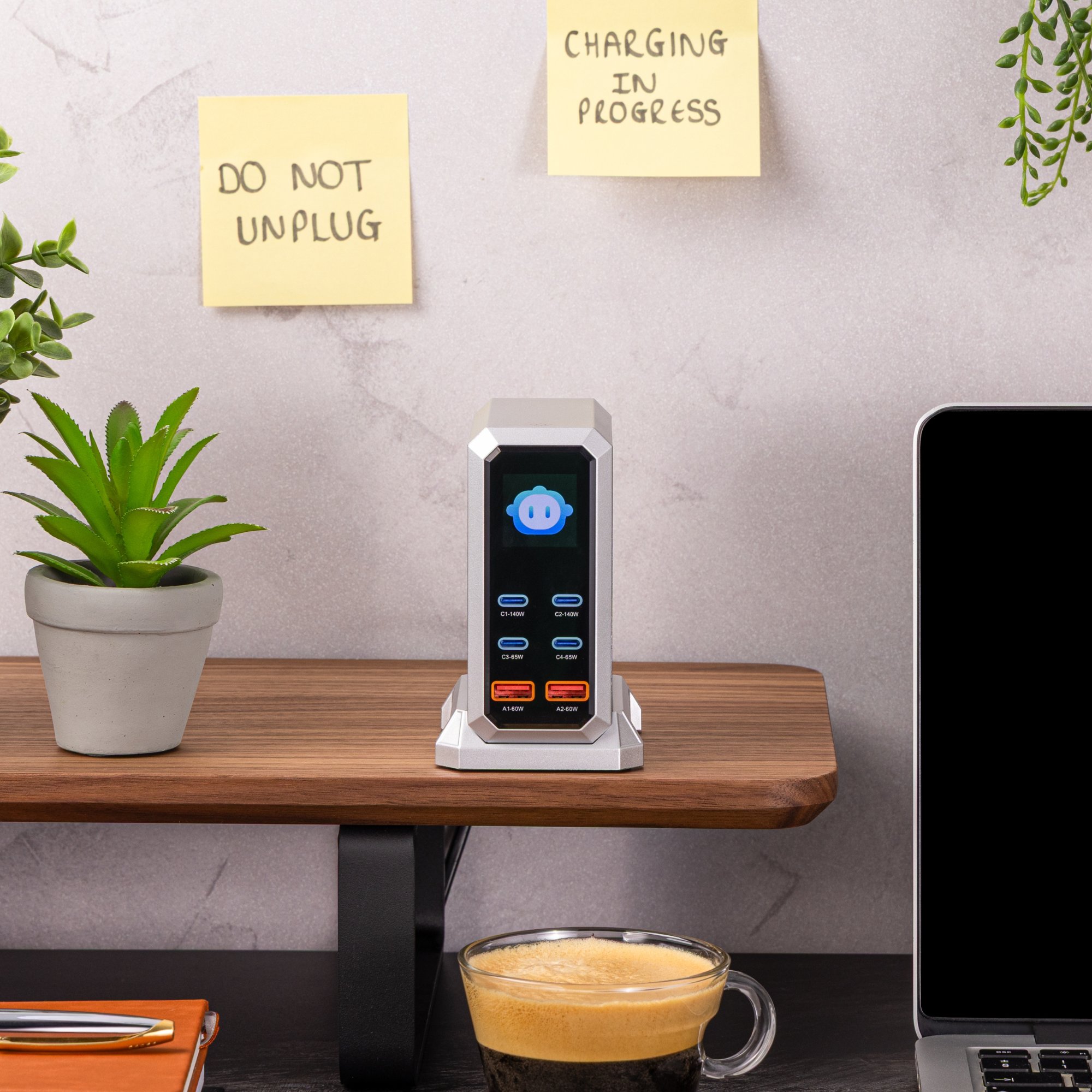 USB charging station on a desk, organizing multiple electronic devices with a small green plant in the background